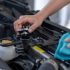 Hands filling water into the car's radiator